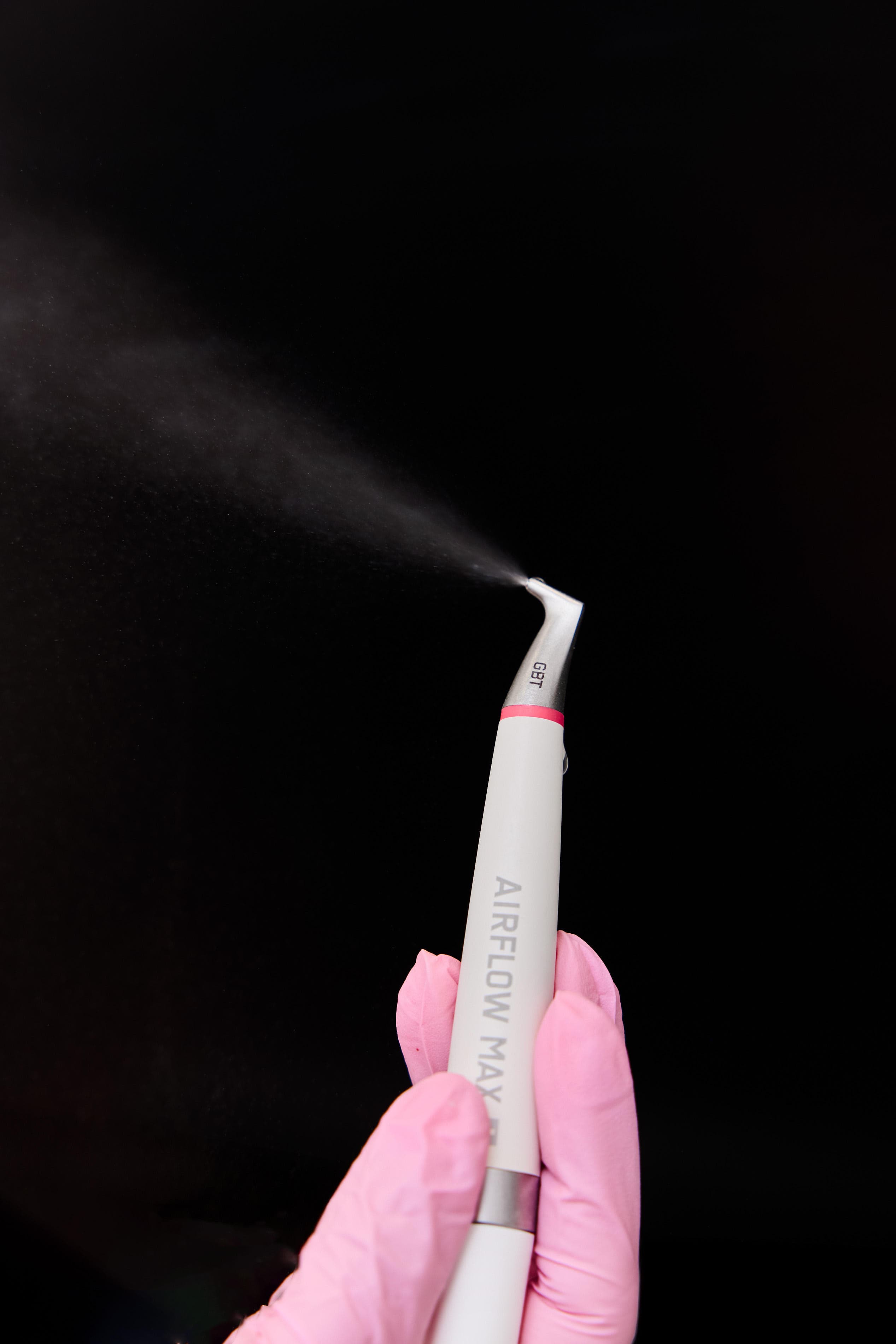Guided Biofilm Therapy AIRFLOW handpiece spraying a fine mist