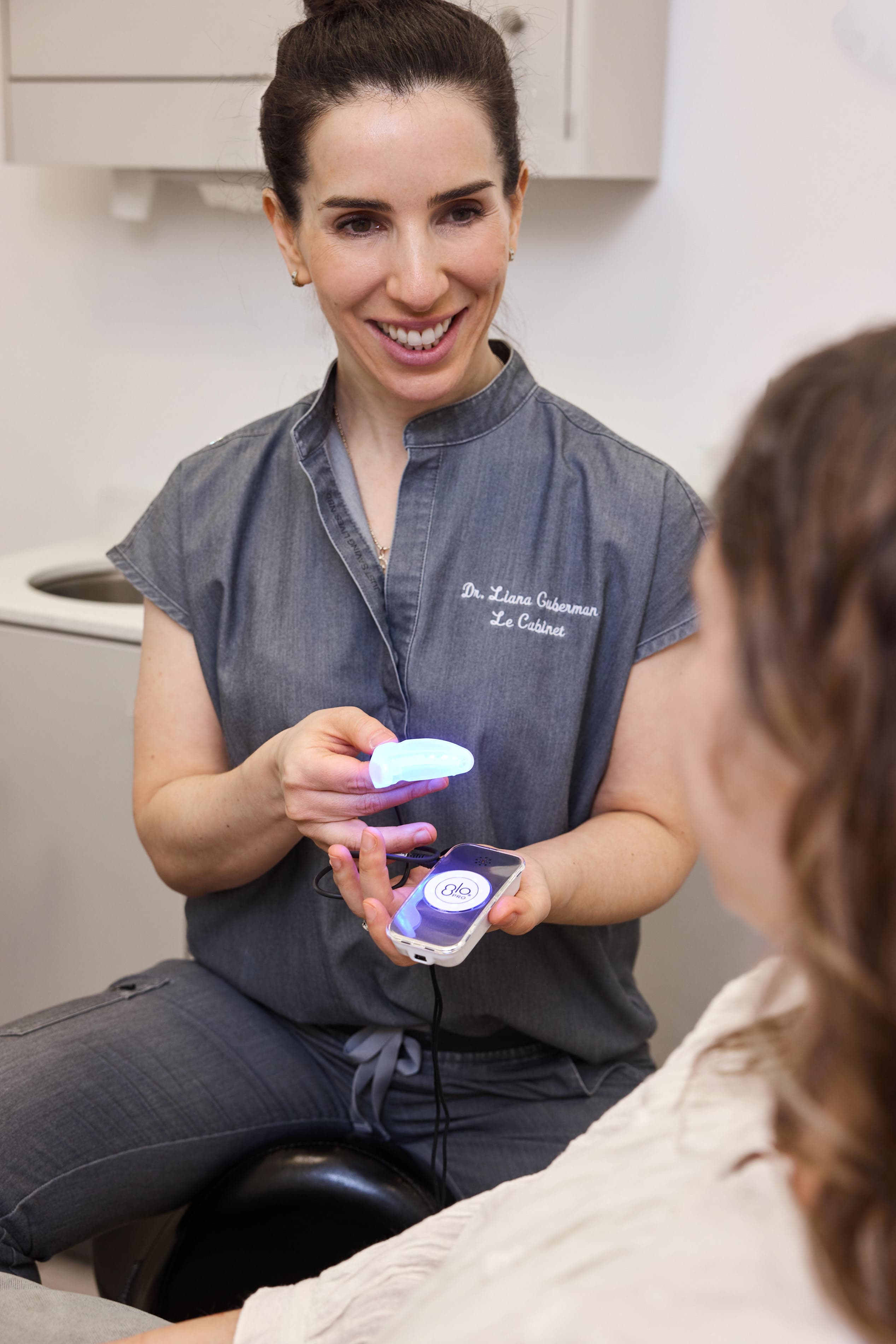 Dr. Liana Guberman demonstrating the GLO professional whitening device